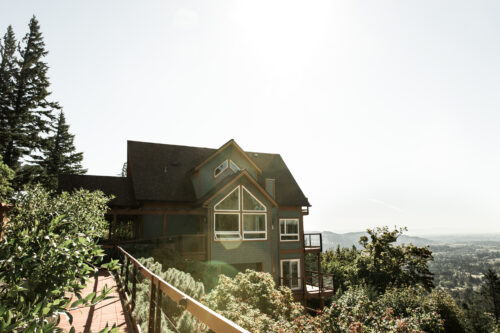 A beautiful B&B on the edge of a hill overlooking lush green fields.