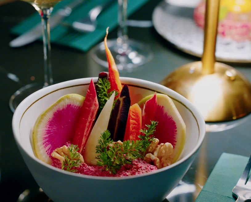 Beet hummus with fresh radishes, served in a bowl and garnished with curly parsley