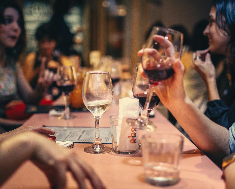 People talking and drinking wine at a restaurant table