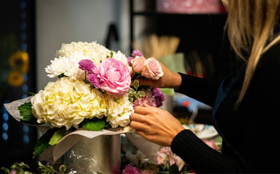 Person arranging a floral bouquet